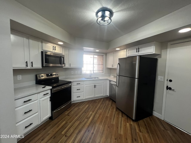 kitchen with sink, a textured ceiling, appliances with stainless steel finishes, dark hardwood / wood-style flooring, and white cabinetry