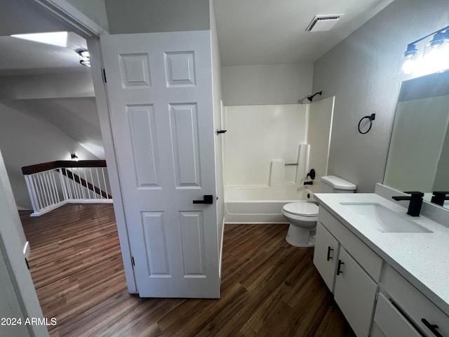 full bathroom with hardwood / wood-style floors, vanity, toilet, and  shower combination