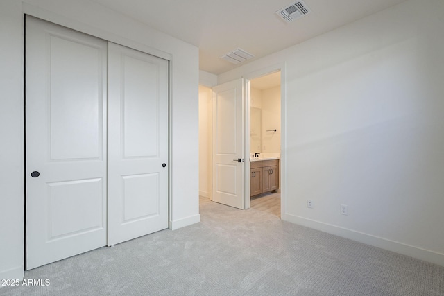 unfurnished bedroom featuring light carpet and a closet