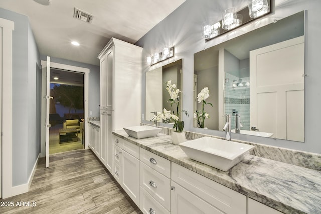 bathroom featuring vanity, a shower with shower door, and wood-type flooring