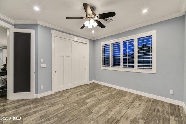 unfurnished bedroom featuring ornamental molding, hardwood / wood-style flooring, and a closet