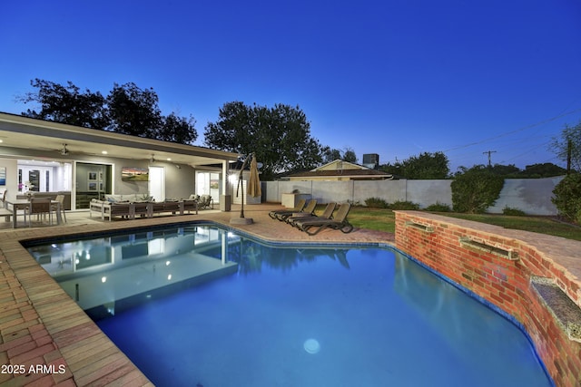 pool at dusk featuring a patio area, an outdoor living space, and ceiling fan