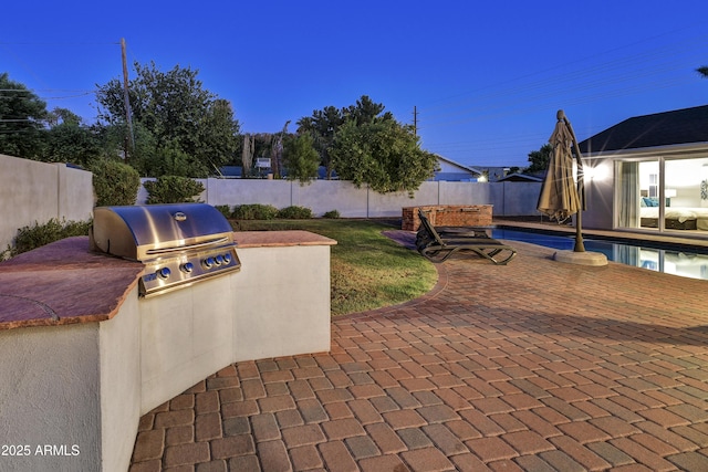 view of patio with grilling area, area for grilling, and a fenced in pool