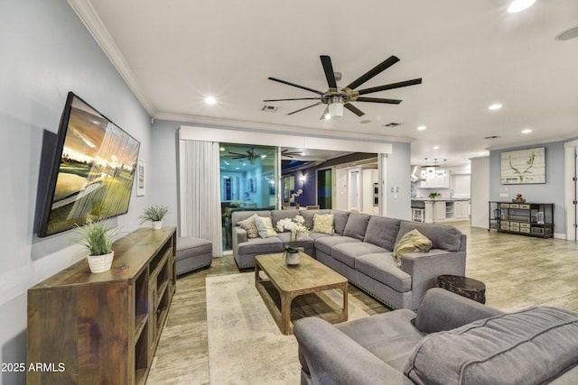 living room featuring light wood-type flooring, ornamental molding, and ceiling fan