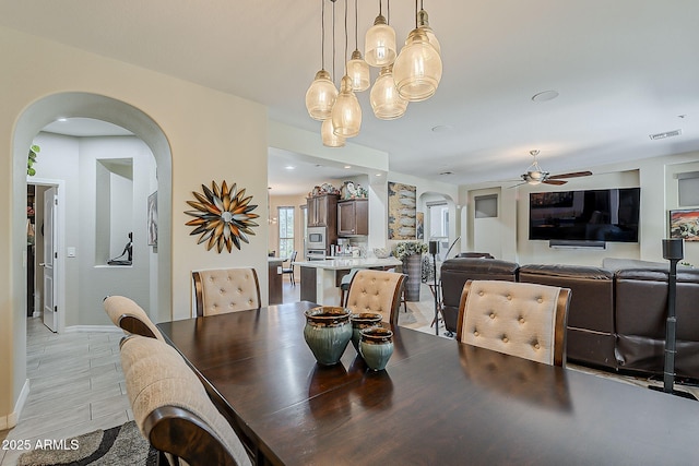 12738 W Brookhart Way, Peoria, AZ 85383 - dining area with arched walkways, ceiling fan, baseboards, and a chandelier