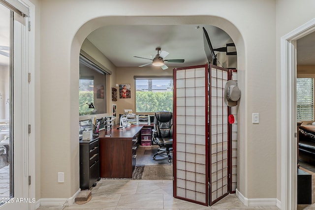 12738 W Brookhart Way, Peoria, AZ 85383 - home office featuring arched walkways, a ceiling fan, light tile patterned floors, and baseboards