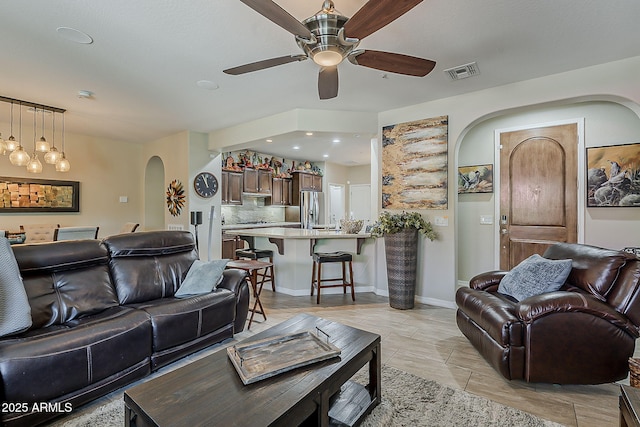 12738 W Brookhart Way, Peoria, AZ 85383 - living room with arched walkways, a ceiling fan, and baseboards