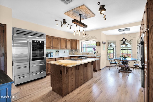 1338 W Mountain View Dr, Mesa, AZ 85201 - kitchen featuring built in refrigerator, light countertops, a center island, decorative backsplash, and light wood-style flooring