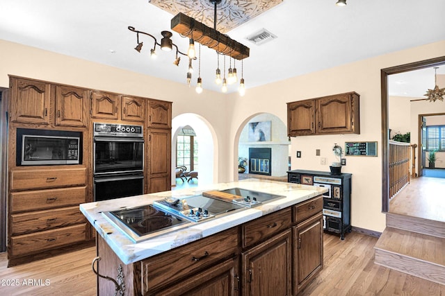 1338 W Mountain View Dr, Mesa, AZ 85201 - kitchen with black appliances, light wood-style floors, a center island, and plenty of natural light