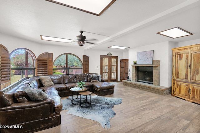 1338 W Mountain View Dr, Mesa, AZ 85201 - living area featuring a brick fireplace, light wood-style flooring, a ceiling fan, and french doors