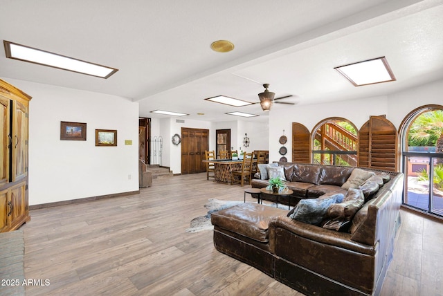 1338 W Mountain View Dr, Mesa, AZ 85201 - living room featuring light wood-style flooring, a ceiling fan, a skylight, and baseboards