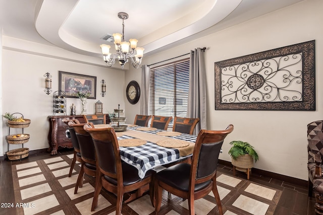 dining area featuring an inviting chandelier and a tray ceiling