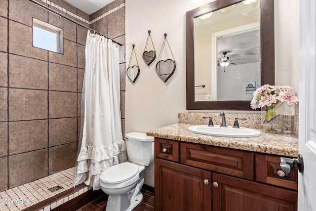 bathroom with ceiling fan, vanity, toilet, and curtained shower