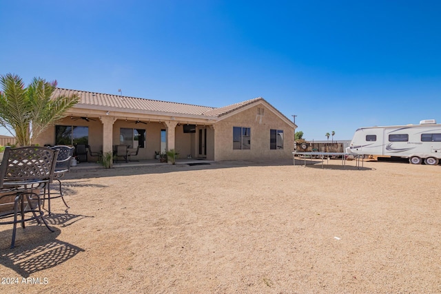 rear view of property with a trampoline and a patio