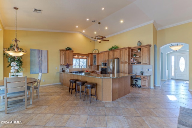 kitchen with kitchen peninsula, appliances with stainless steel finishes, a breakfast bar, ceiling fan, and stone countertops