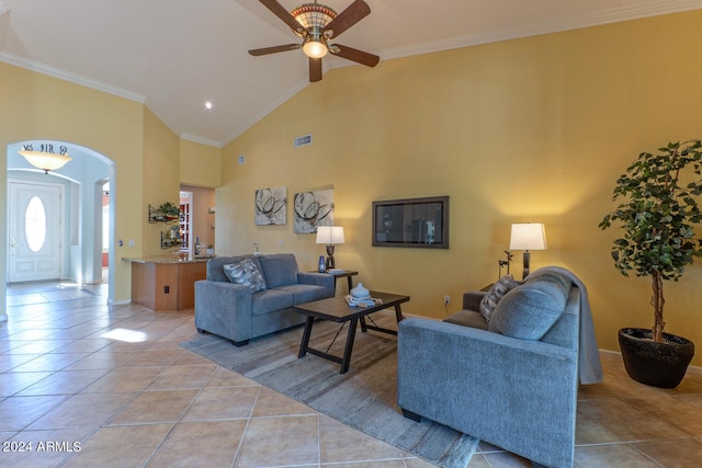 tiled living room featuring ceiling fan, vaulted ceiling, and ornamental molding