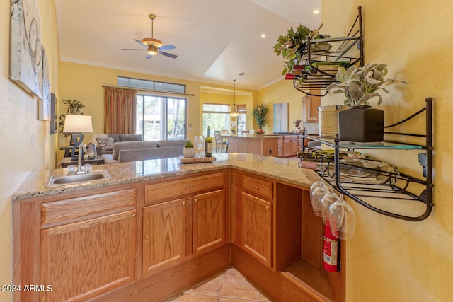 kitchen with light stone countertops, vaulted ceiling, ceiling fan, sink, and light tile patterned flooring