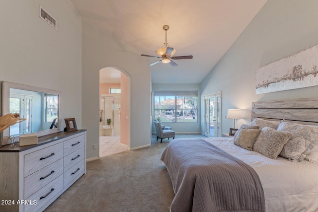 bedroom featuring ensuite bath, light carpet, ceiling fan, and high vaulted ceiling