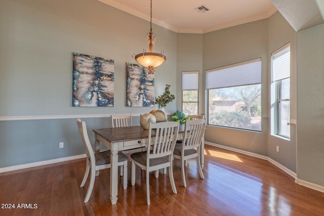 dining space featuring ornamental molding and hardwood / wood-style flooring