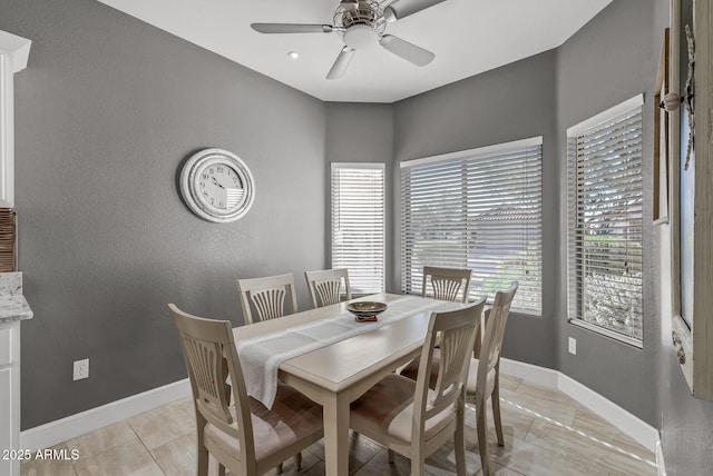 dining room with baseboards, light tile patterned floors, and ceiling fan