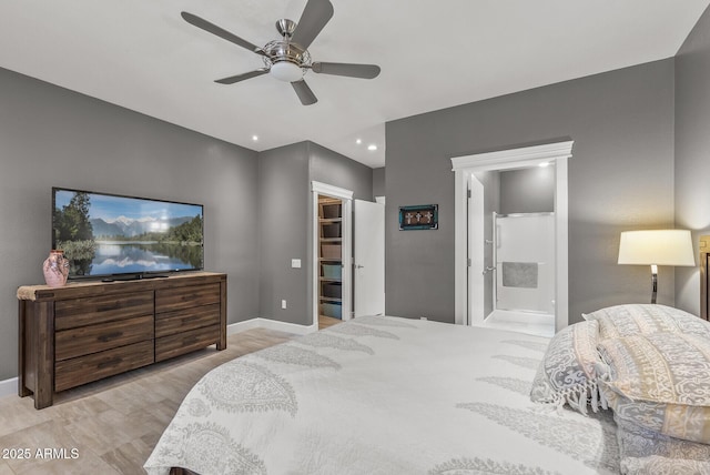 bedroom featuring a walk in closet, ceiling fan, connected bathroom, and baseboards