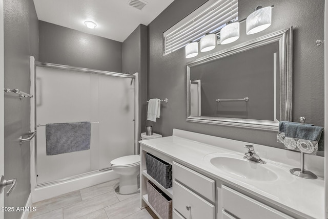 full bath featuring toilet, visible vents, a shower stall, and vanity