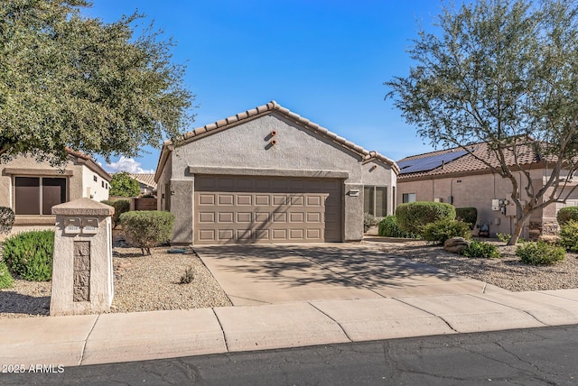 view of front of house featuring stucco siding, concrete driveway, a tile roof, and a garage
