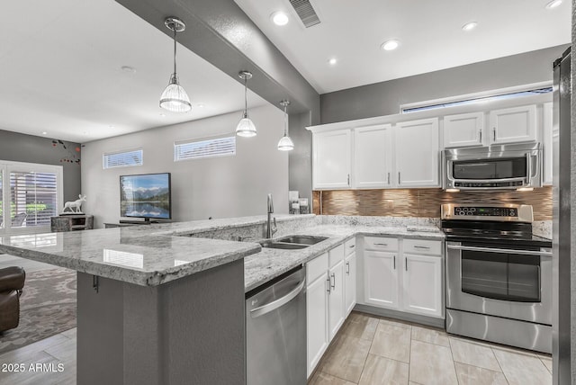 kitchen with a sink, white cabinets, a peninsula, and stainless steel appliances