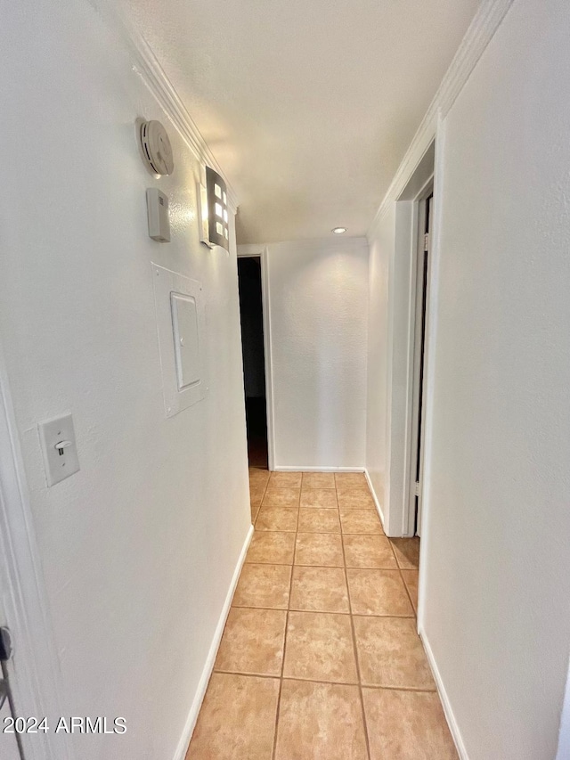 hall with crown molding and light tile patterned floors