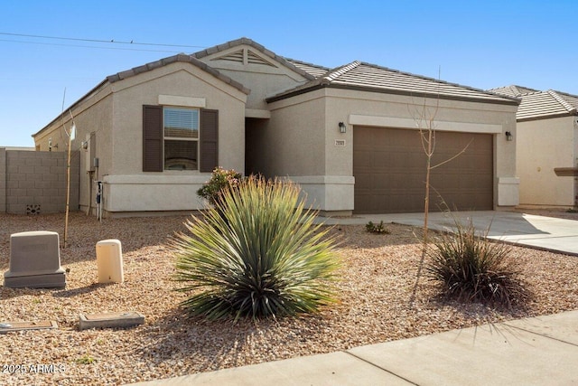 ranch-style house featuring a garage, a tile roof, driveway, and stucco siding