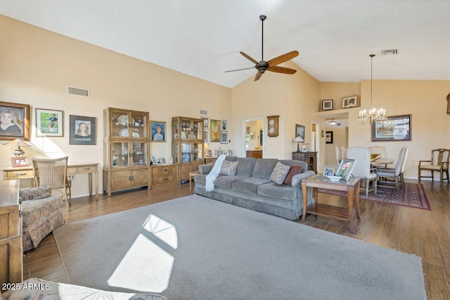 living room featuring visible vents, ceiling fan with notable chandelier, dark wood-style floors, and high vaulted ceiling