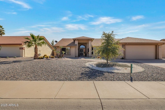 view of front of house with stucco siding, driveway, and a garage