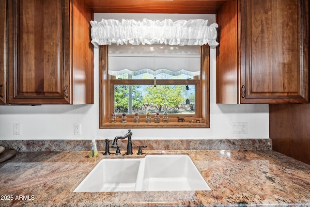 kitchen featuring light stone countertops and sink