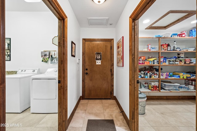 laundry area featuring light tile patterned floors and washer and dryer