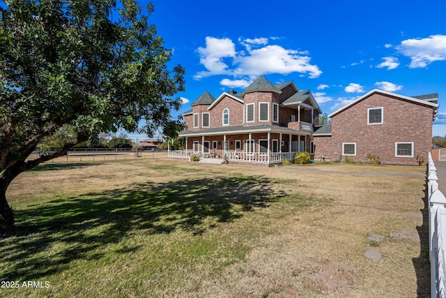 rear view of house with a yard and a porch