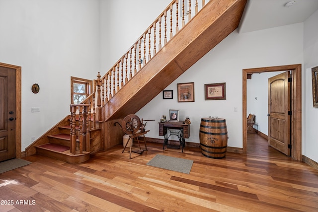 foyer entrance featuring hardwood / wood-style floors and a high ceiling