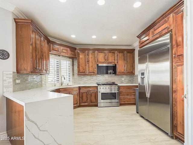 4530 W Misty Willow Ln, Glendale, AZ 85310 - kitchen with high end appliances, crown molding, sink, tasteful backsplash, and light stone counters