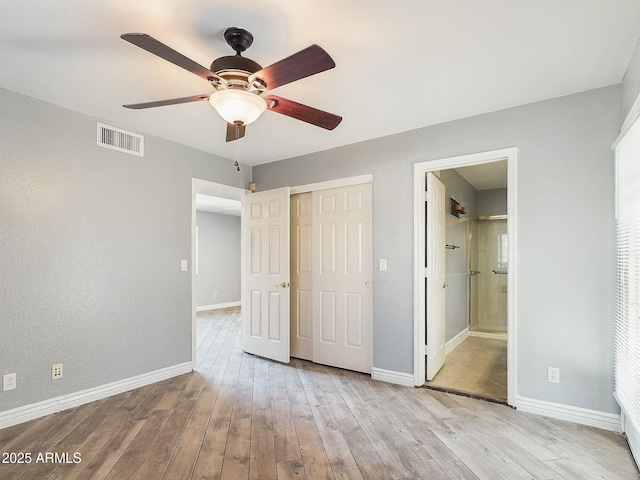 4530 W Misty Willow Ln, Glendale, AZ 85310 - unfurnished bedroom featuring ensuite bath, ceiling fan, a closet, and light wood-type flooring