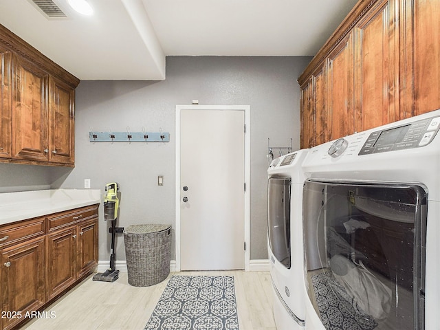 4530 W Misty Willow Ln, Glendale, AZ 85310 - laundry room featuring cabinets, light hardwood / wood-style floors, and washer and clothes dryer