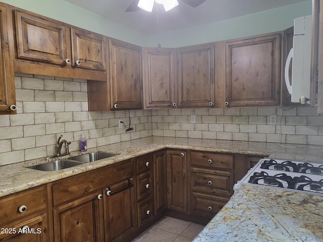 720 N 82nd St Unit E116, Scottsdale, AZ 85257 - kitchen featuring white microwave, a sink, ceiling fan, tasteful backsplash, and light stone countertops