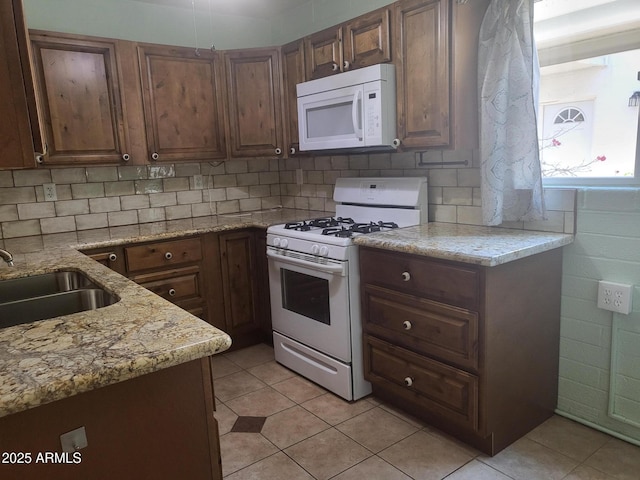 720 N 82nd St Unit E116, Scottsdale, AZ 85257 - kitchen with white appliances, a sink, light tile patterned floors, and light stone countertops