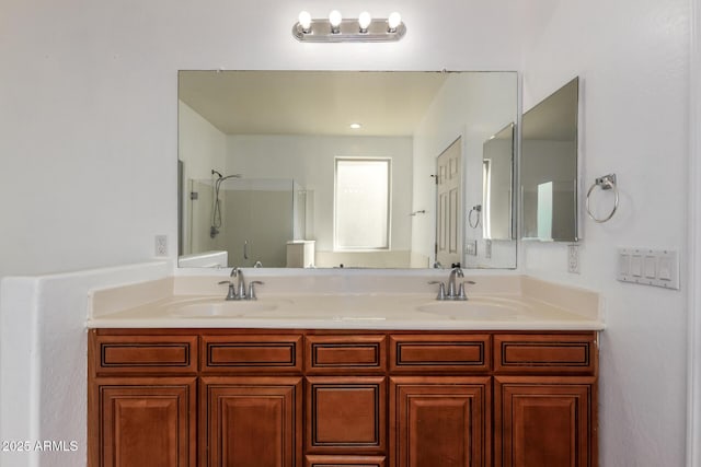 full bath with a shower, double vanity, and a sink