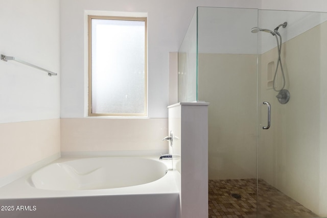 bathroom featuring a garden tub and a shower stall