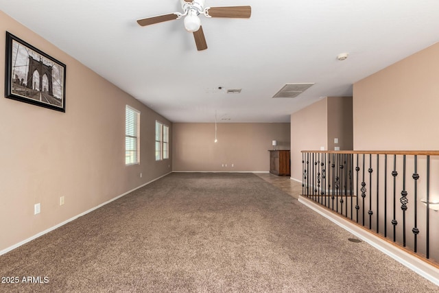 unfurnished room featuring carpet floors, visible vents, and baseboards