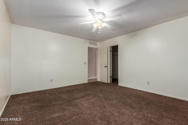 unfurnished room featuring a ceiling fan, dark colored carpet, visible vents, and baseboards