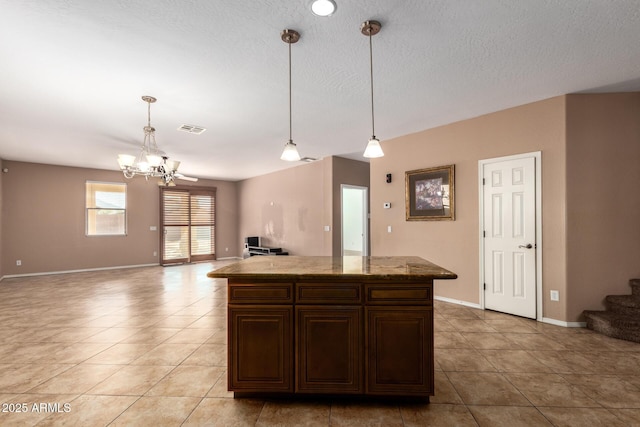 kitchen with open floor plan, visible vents, decorative light fixtures, and light tile patterned flooring