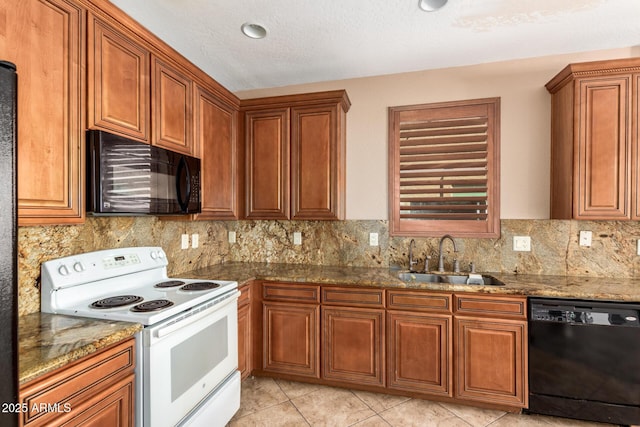 kitchen featuring black appliances, brown cabinetry, a sink, and decorative backsplash