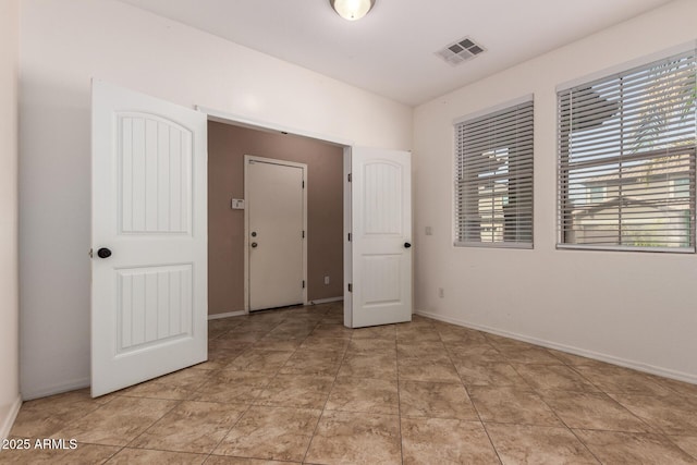 unfurnished bedroom featuring visible vents and baseboards