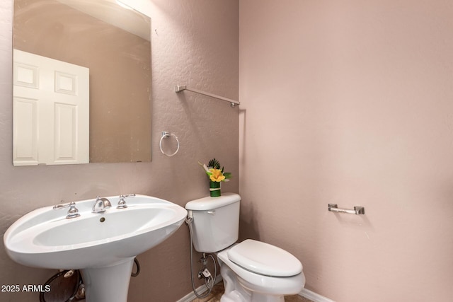 bathroom with baseboards and toilet