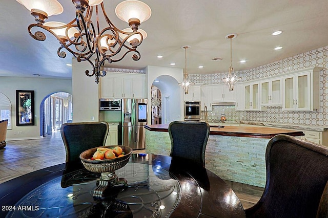 dining space featuring dark parquet flooring and an inviting chandelier